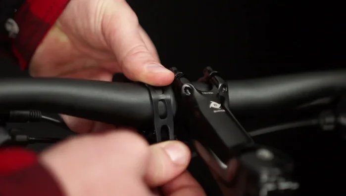 Stretch the rubber straps around the handlebar and catch the hook securely through a notch.
