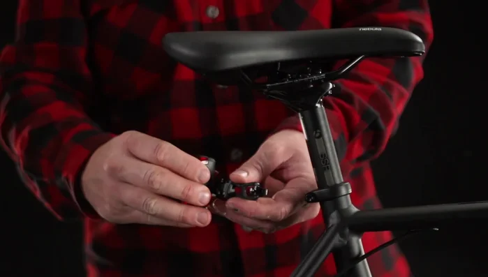 Hold the bracket so the widest part of the wedge faces the ground and the saddle icon is upright.