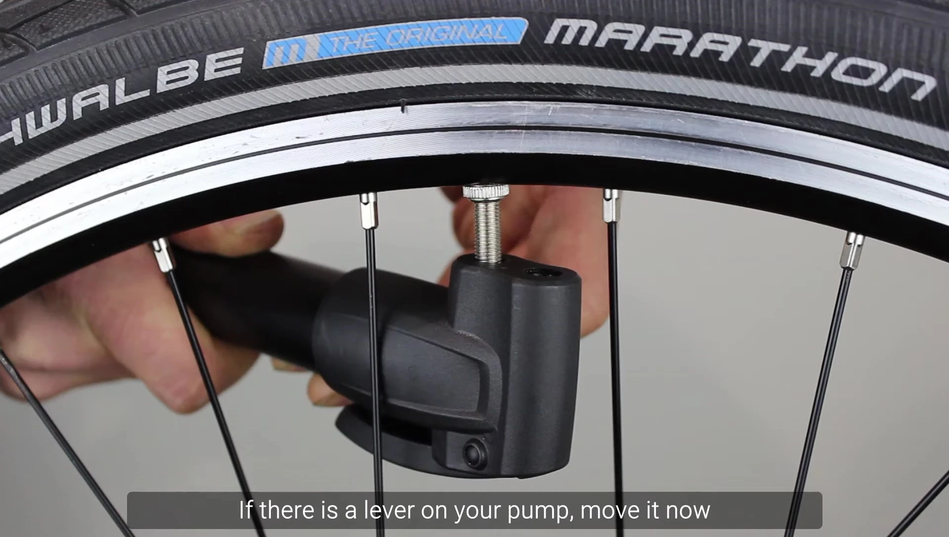 Pumping the bicycle tire with the pump adapter secured to the Presta valve.