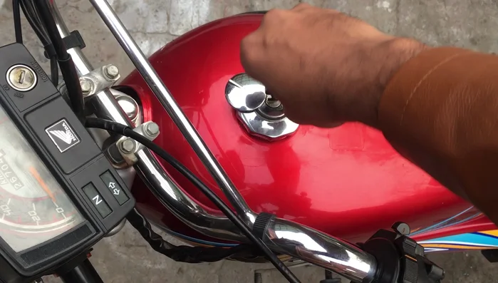 Work the oil in: Open and close the fuel cap several times to distribute the oil.