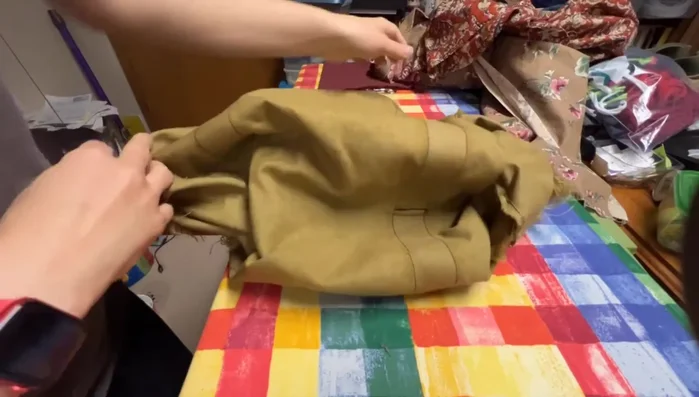 Carefully remove the remaining stitches in the damaged area using a seam ripper.