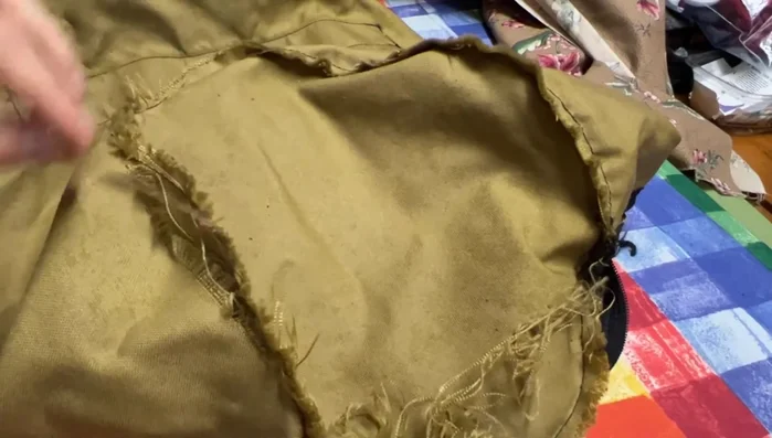 Carefully remove the remaining stitches in the damaged area using a seam ripper.