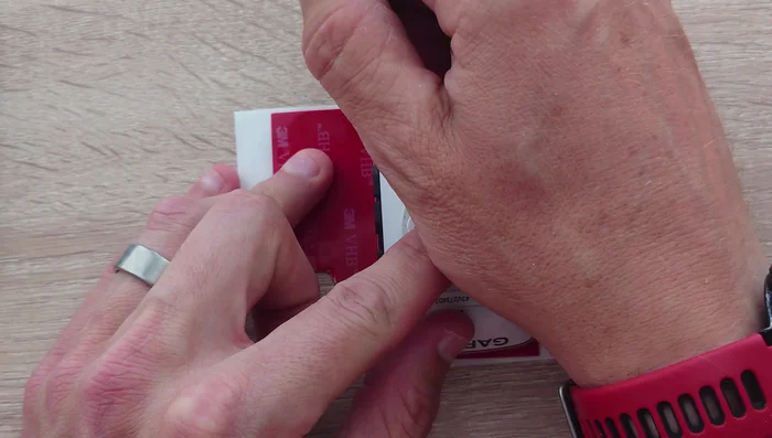 Cut a piece of adhesive to fit around the inner part of the plastic unit, leaving a border of 2-3 millimeters.