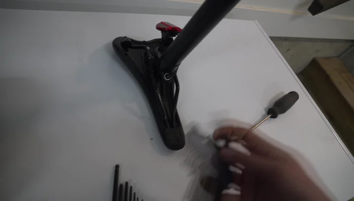 Unscrew the seat from the rails by hand.