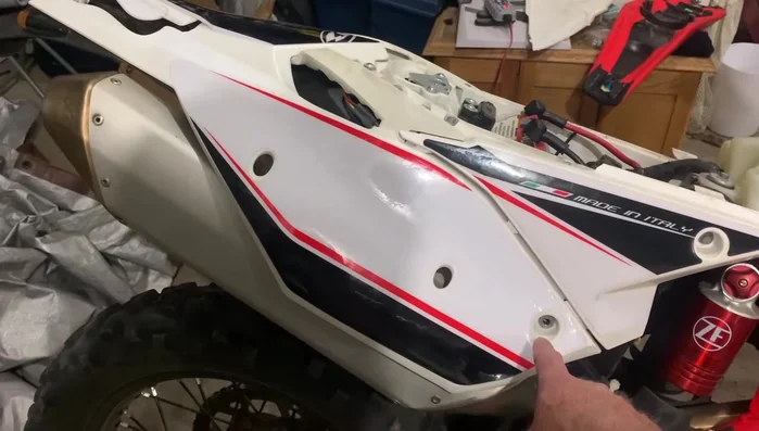 Disconnect the fender from the bottom of the bike by removing an 8mm bolt in the center.