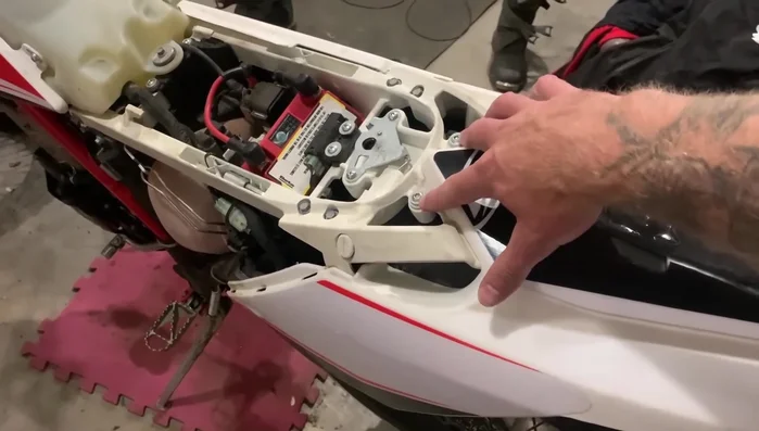 Disconnect the fender from the bottom of the bike by removing an 8mm bolt in the center.