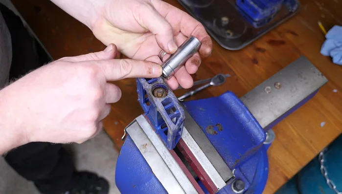 Remove the bearings, carefully supporting the axle to prevent them from falling out. Use a container to collect the bearings.