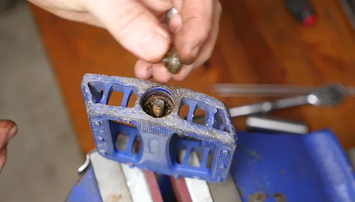 Remove the bearings, carefully supporting the axle to prevent them from falling out. Use a container to collect the bearings.