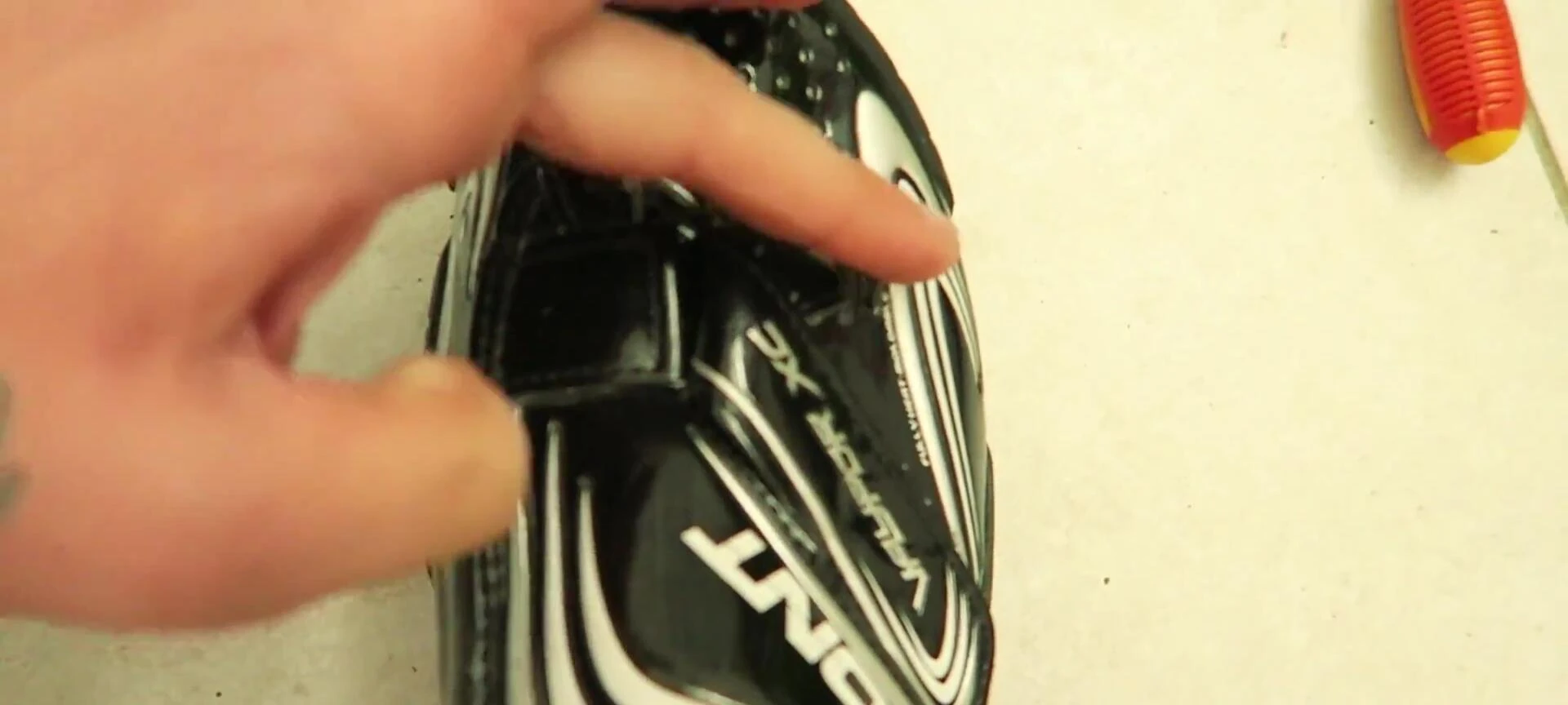 Demonstration of widening the shoes using a screwdriver and special sock