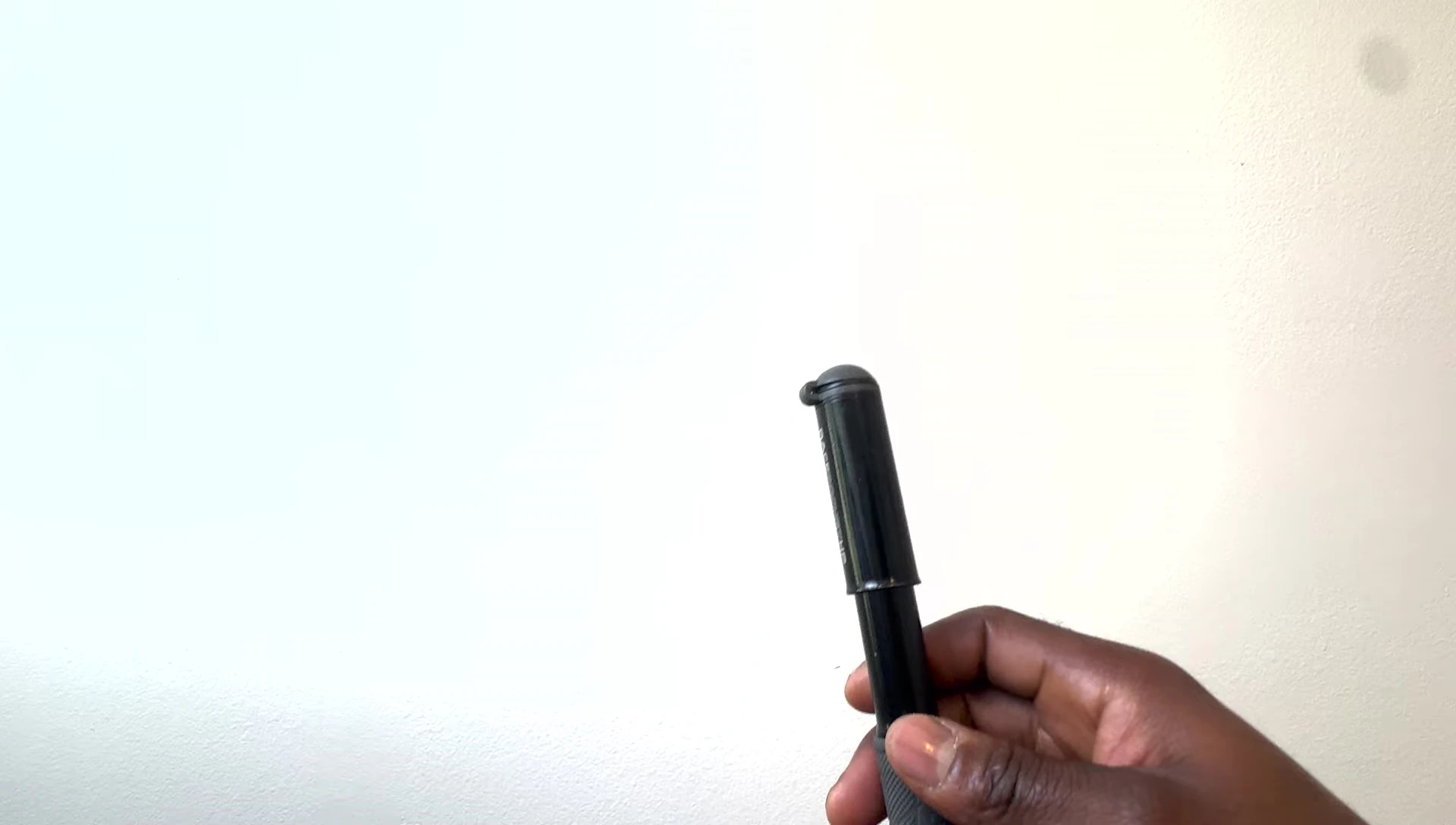 The pump next to a pen, illustrating its compact dimensions.