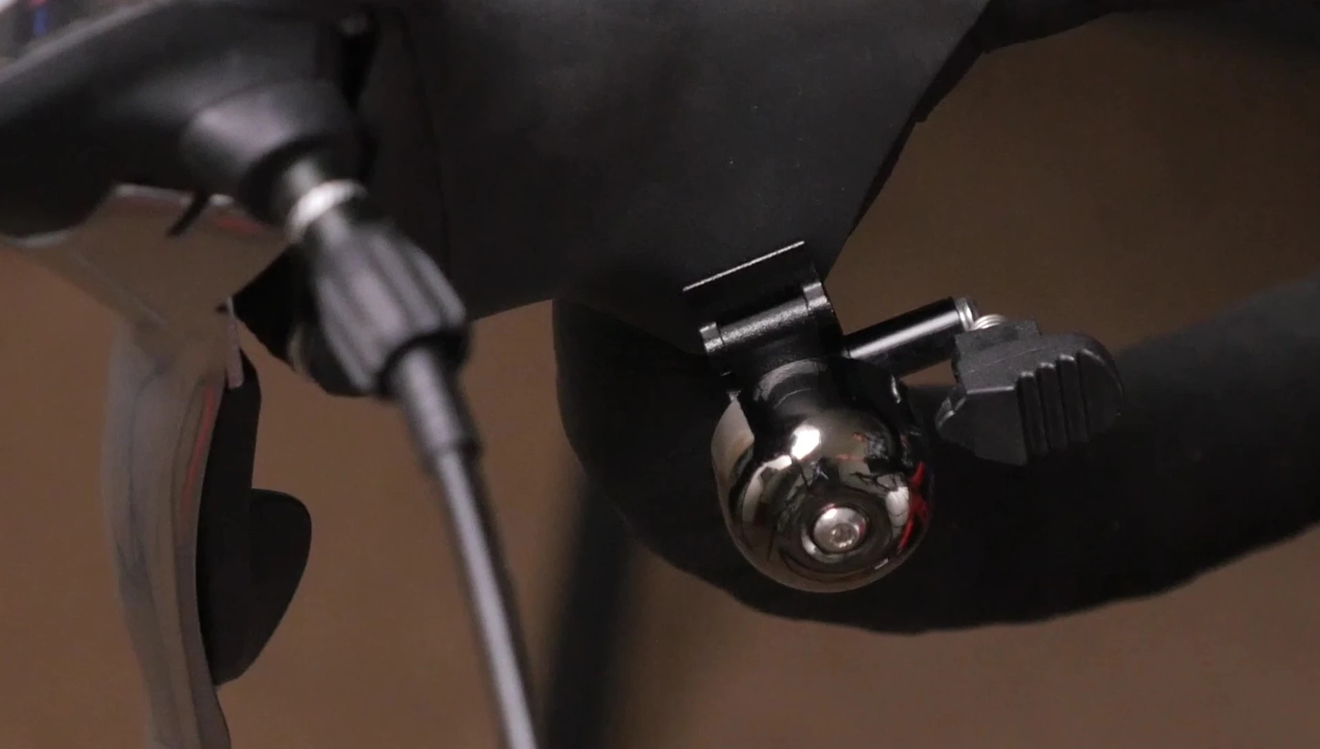 The Osaka Roadie Bell shown in the hand, highlighting its small size