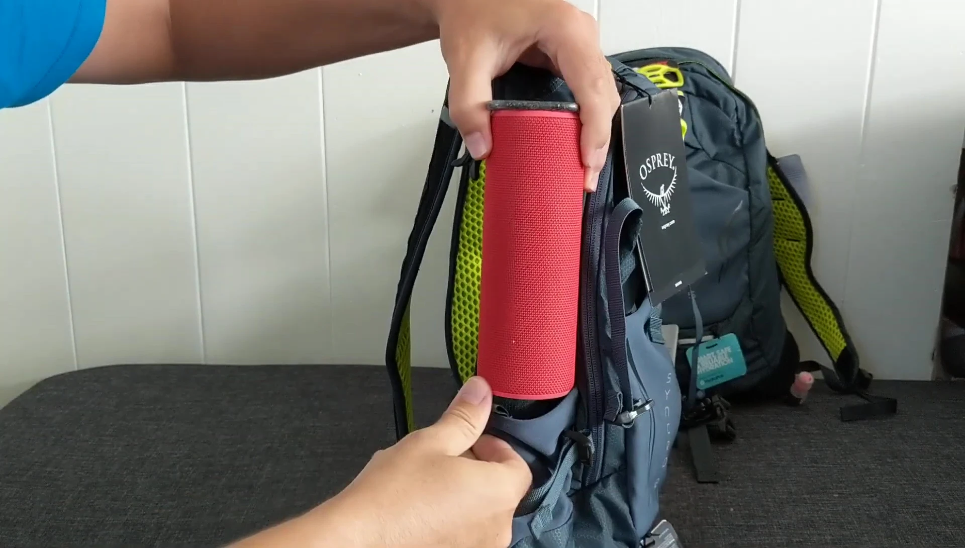 A Bluetooth speaker being placed in the side pocket of the Syncro 12.