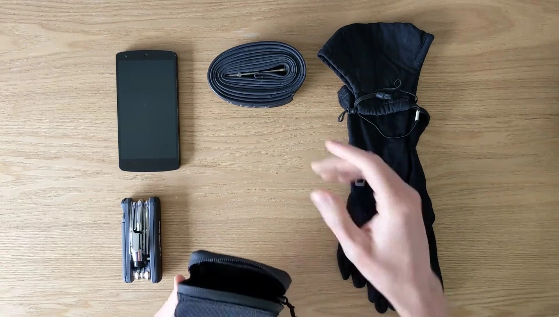 The reviewer begins packing items into the saddle bag.