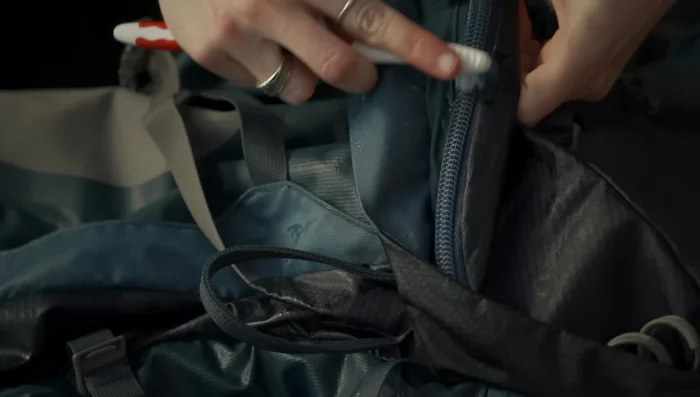 Clean zippers with a brush to remove dirt and sand.