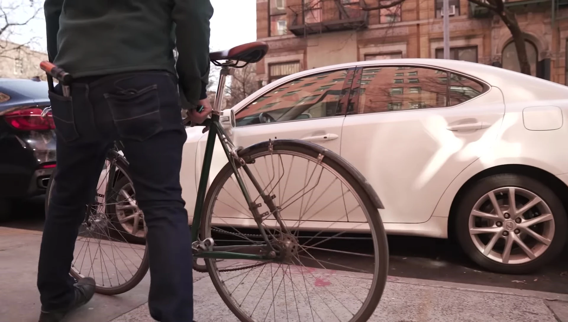 A demonstration of locking a bike to a street sign using a U-lock.