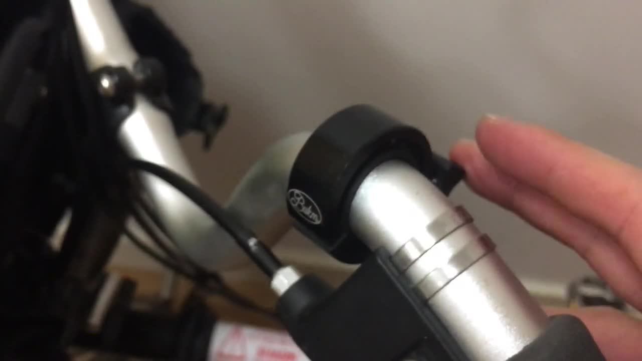 Close-up of the compact bike bell attached to handlebars.