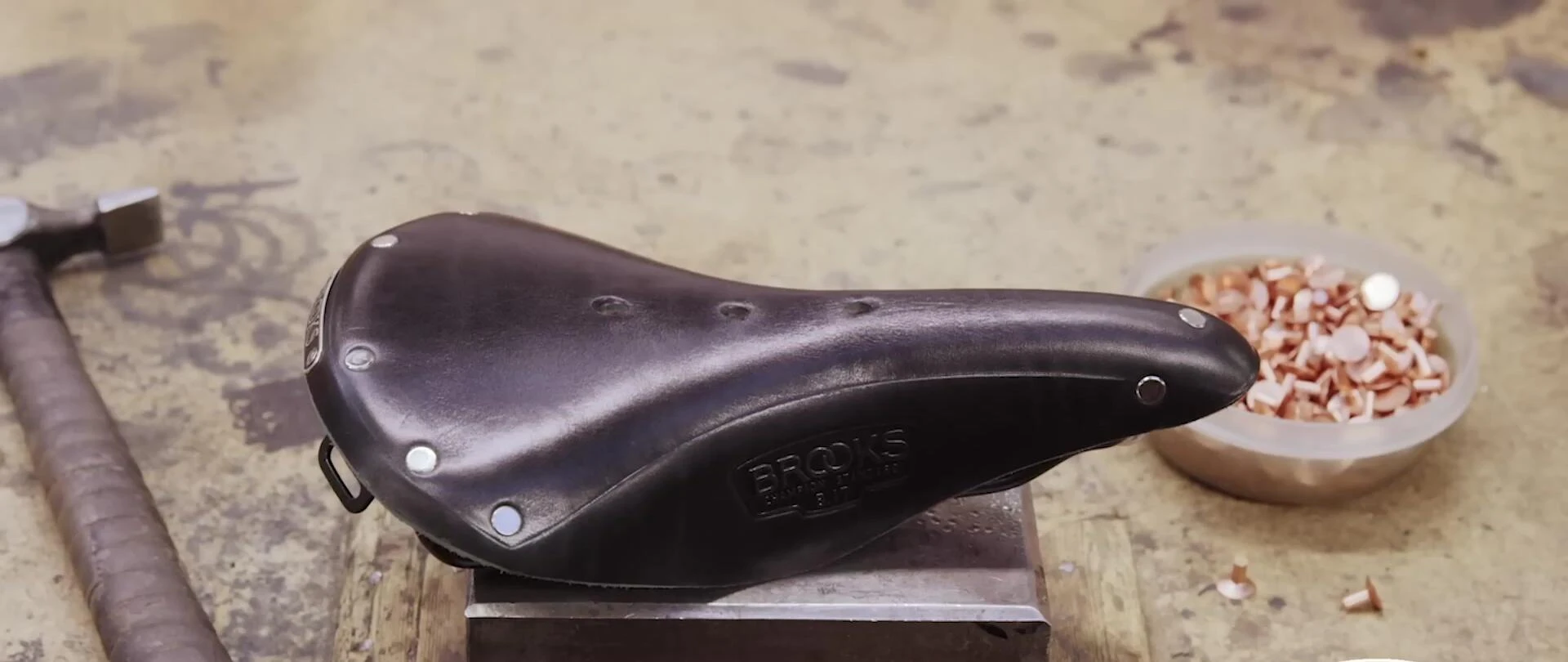 Close-up of a Brooks B17 saddle, highlighting its classic design and stainless steel rivets.