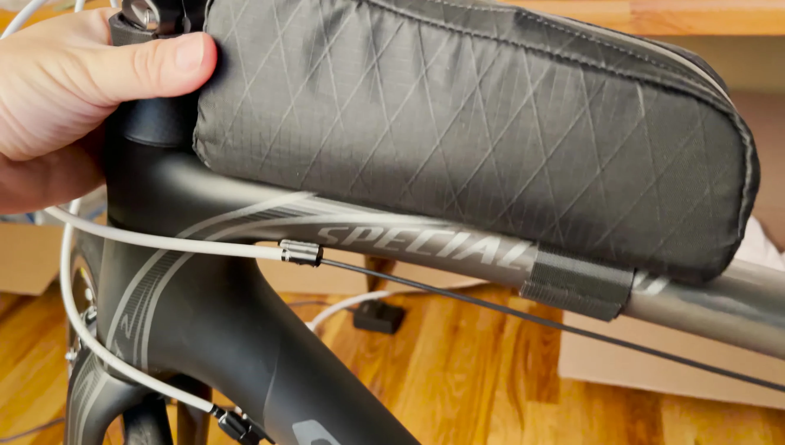 The speaker compares the aerodynamics of the Bontrager bag to the saddle bag.