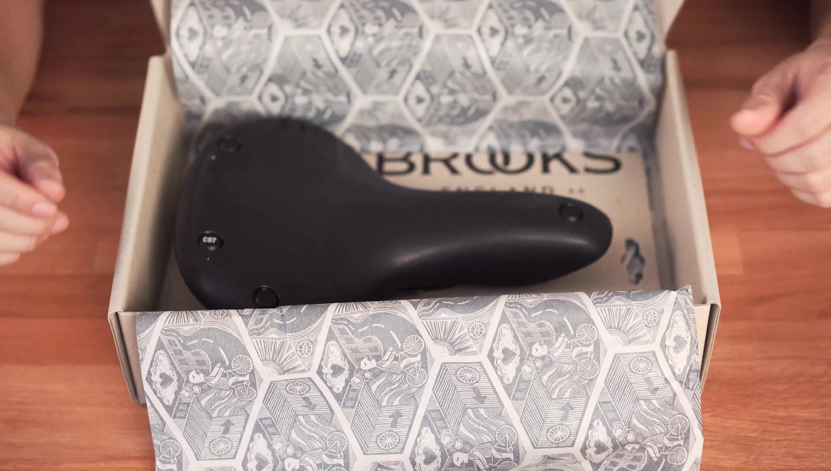 The unboxed Brooks Cambium C67 saddle, highlighting its wide design.