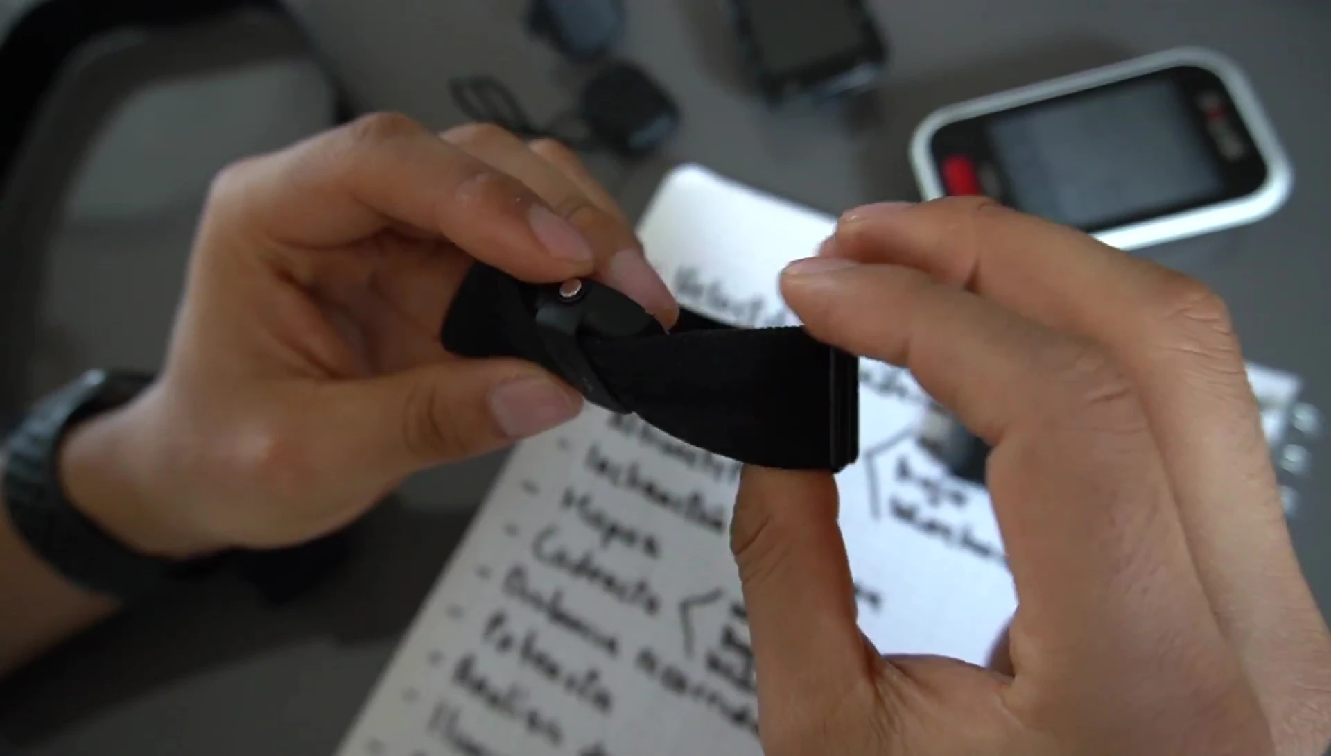 The reviewer shows the recommended Polar heart rate sensor with a rechargeable battery.