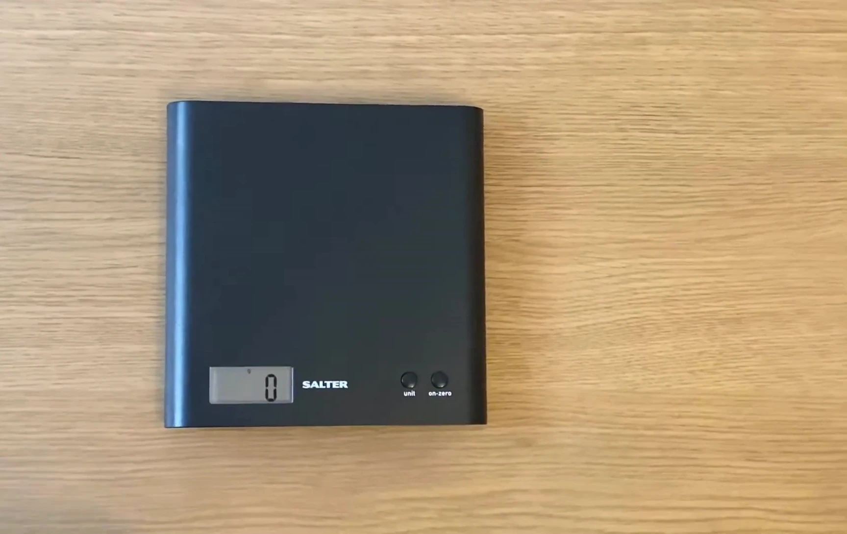 The speaker is showing the scale used to weigh the shoes