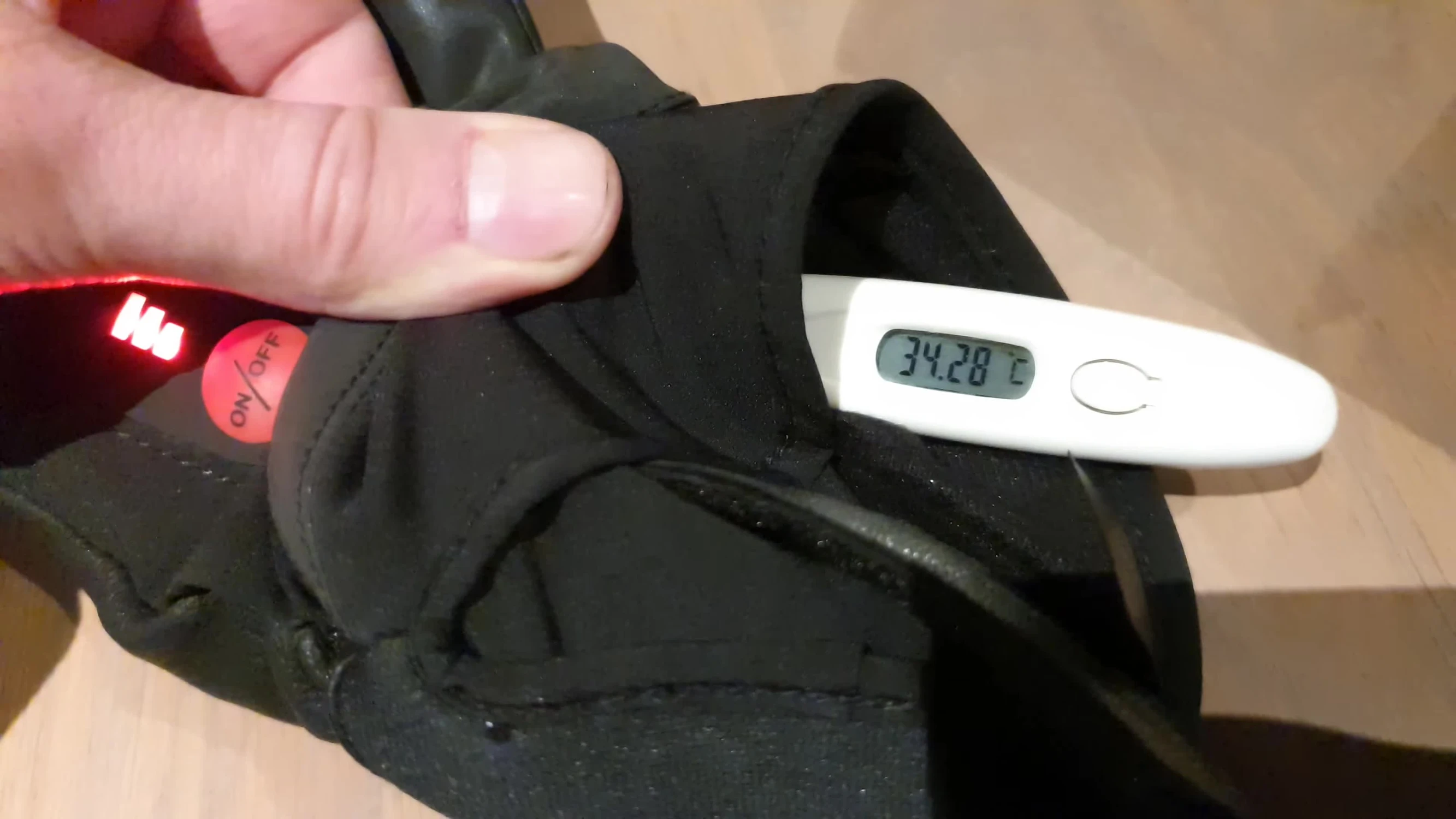 Close-up shot of the glove's temperature display showing 34 degrees Celsius.