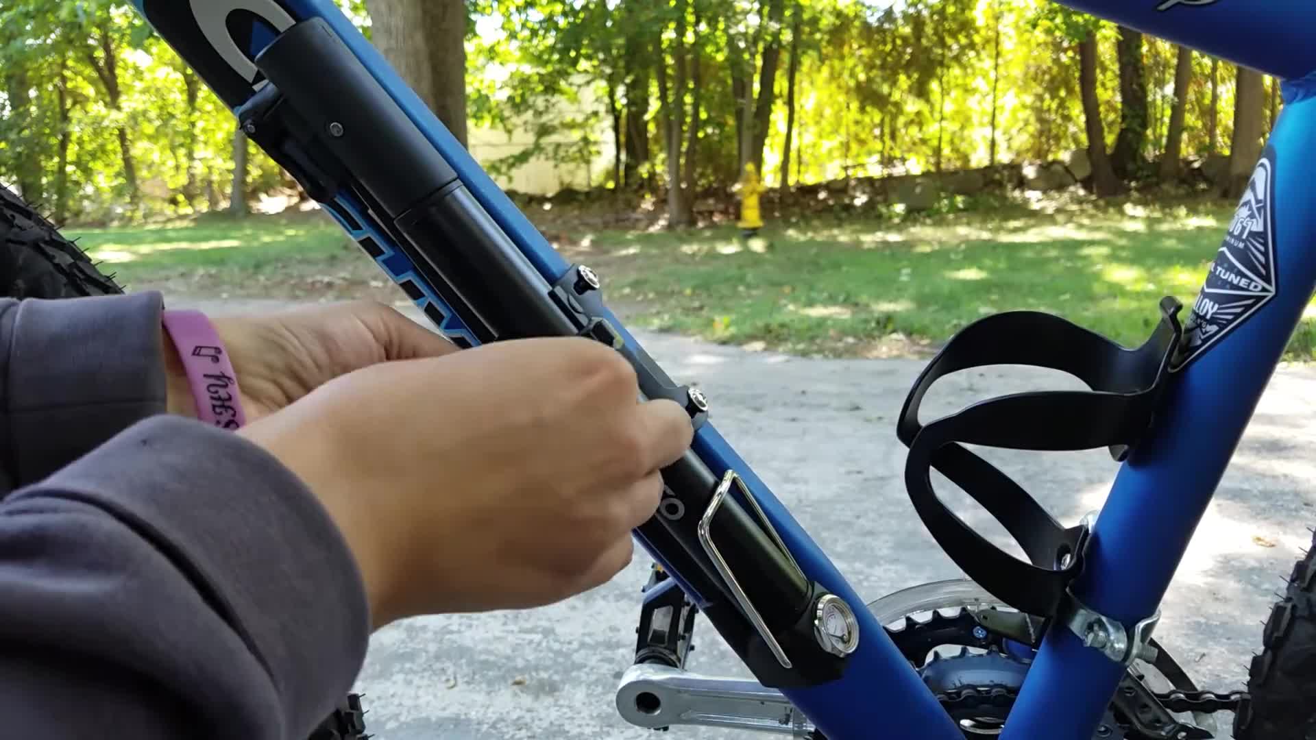 Close-up of the Enkeeo mini bike pump securely mounted on a bicycle frame.