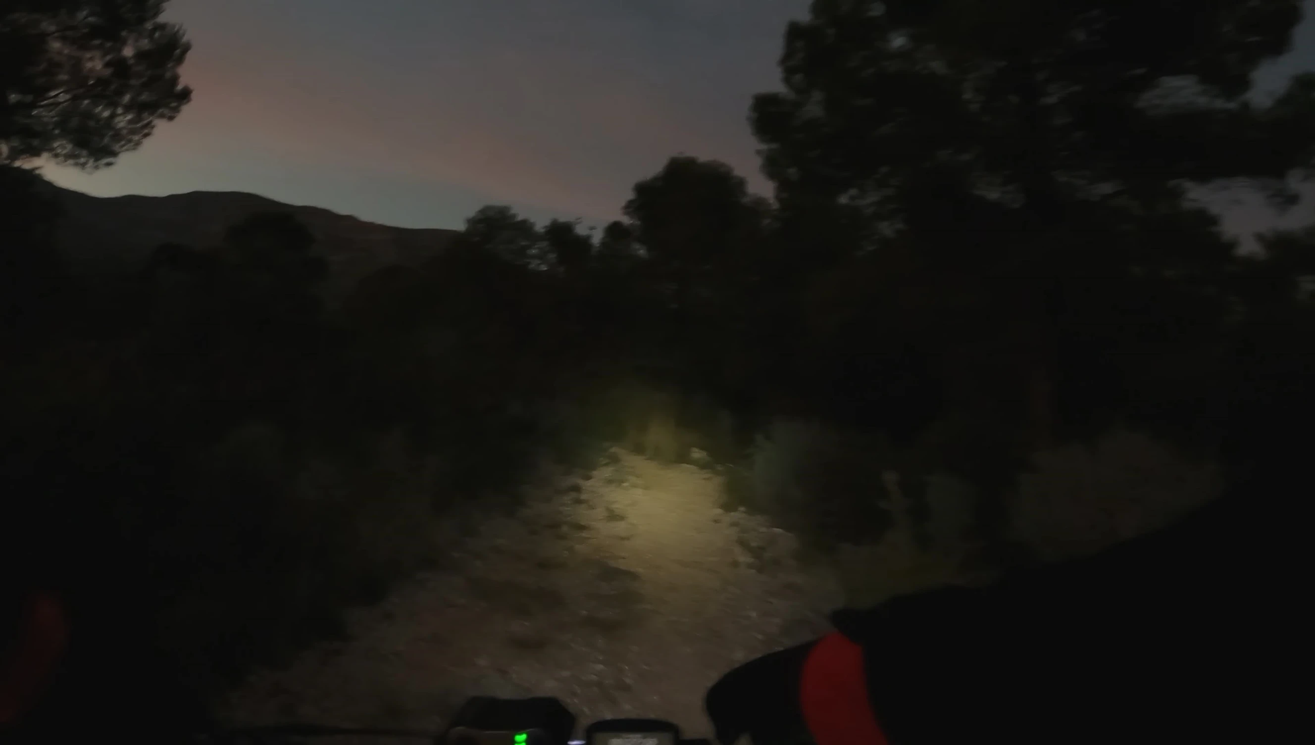 The speaker demonstrating how he controls and adjusts his front lights while riding