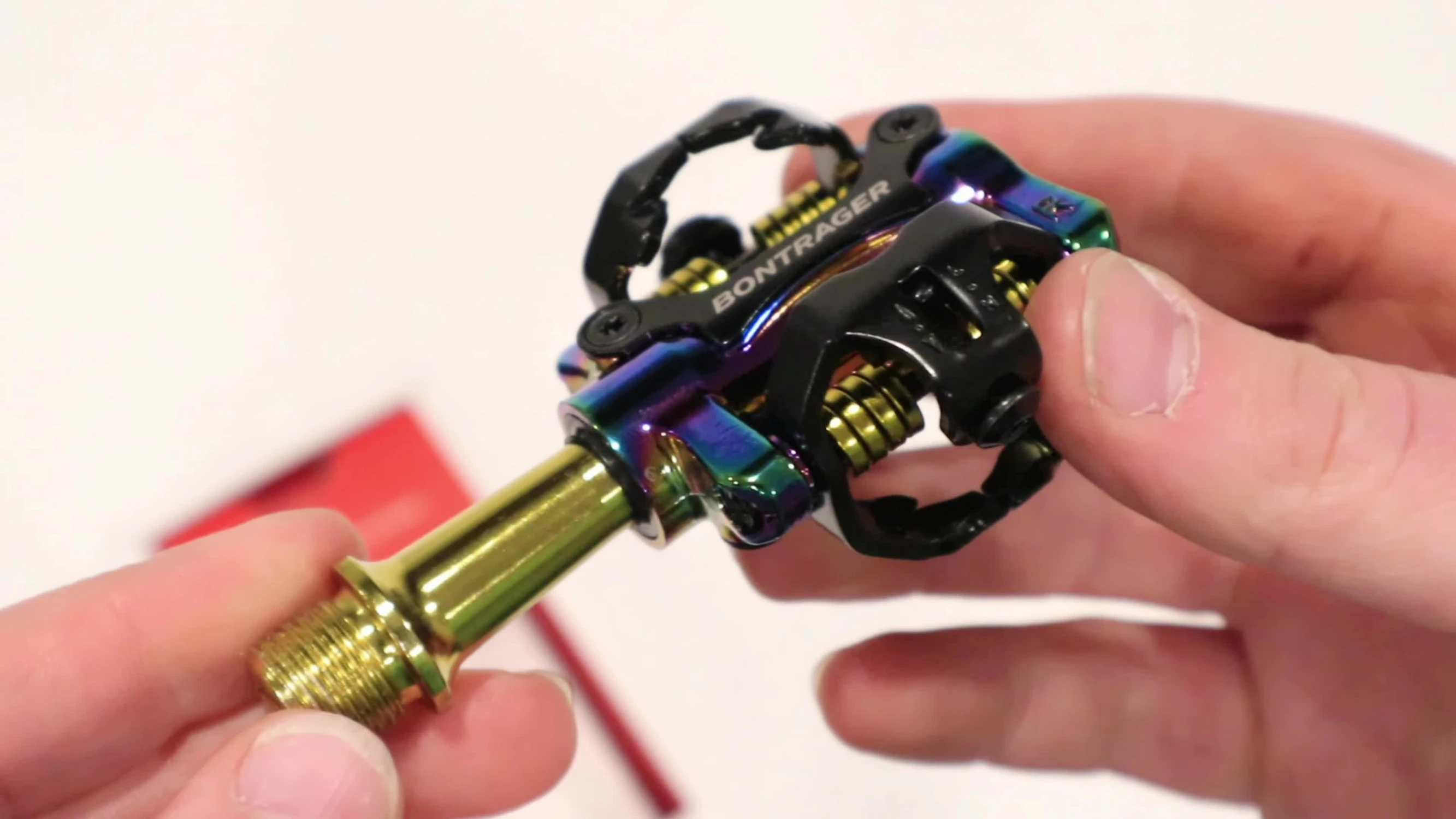 Close-up of the oil slick and gold Bontrager Comp MTB pedals.
