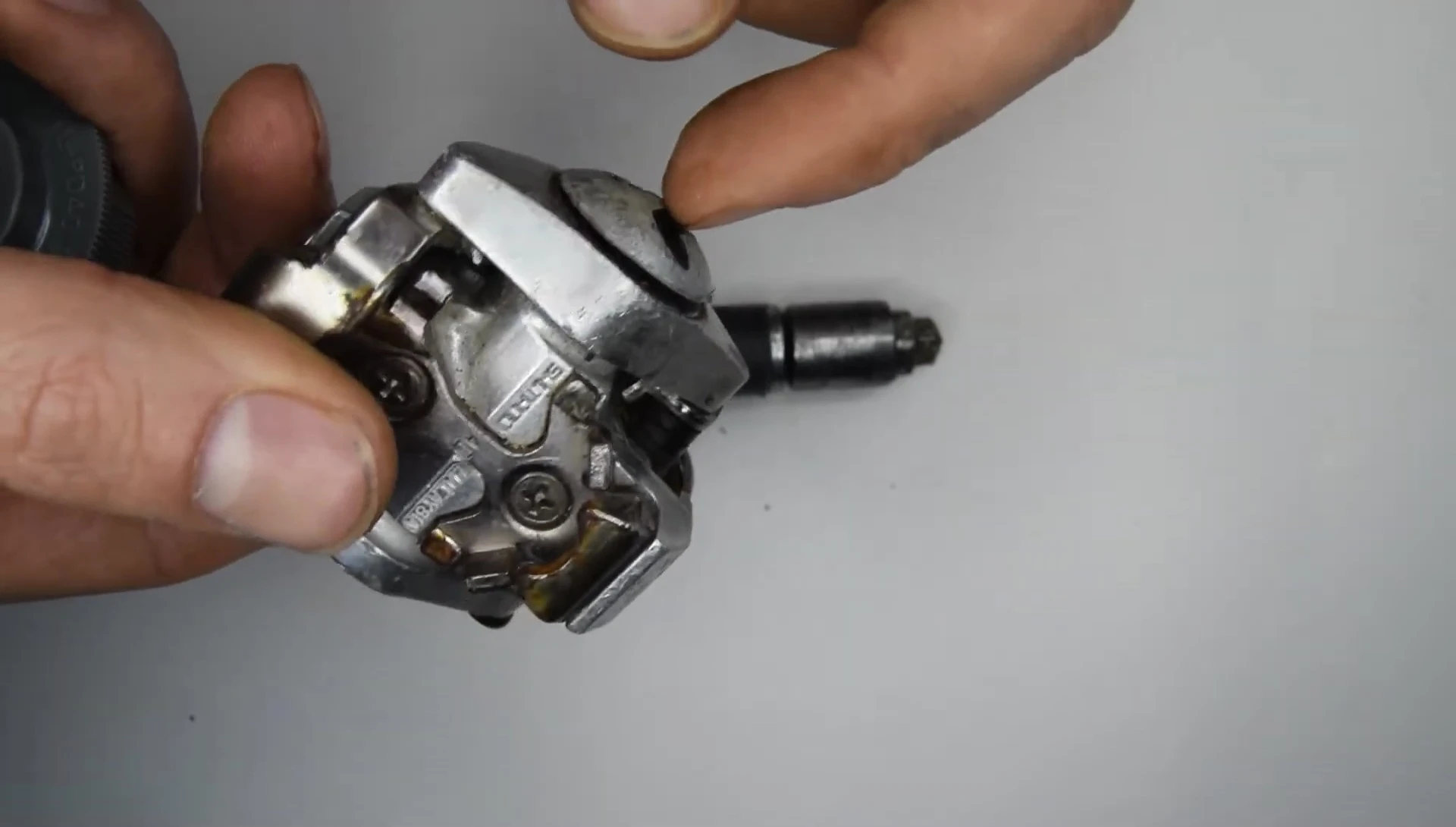 Removing the Phillips screw to access the plastic bushing.