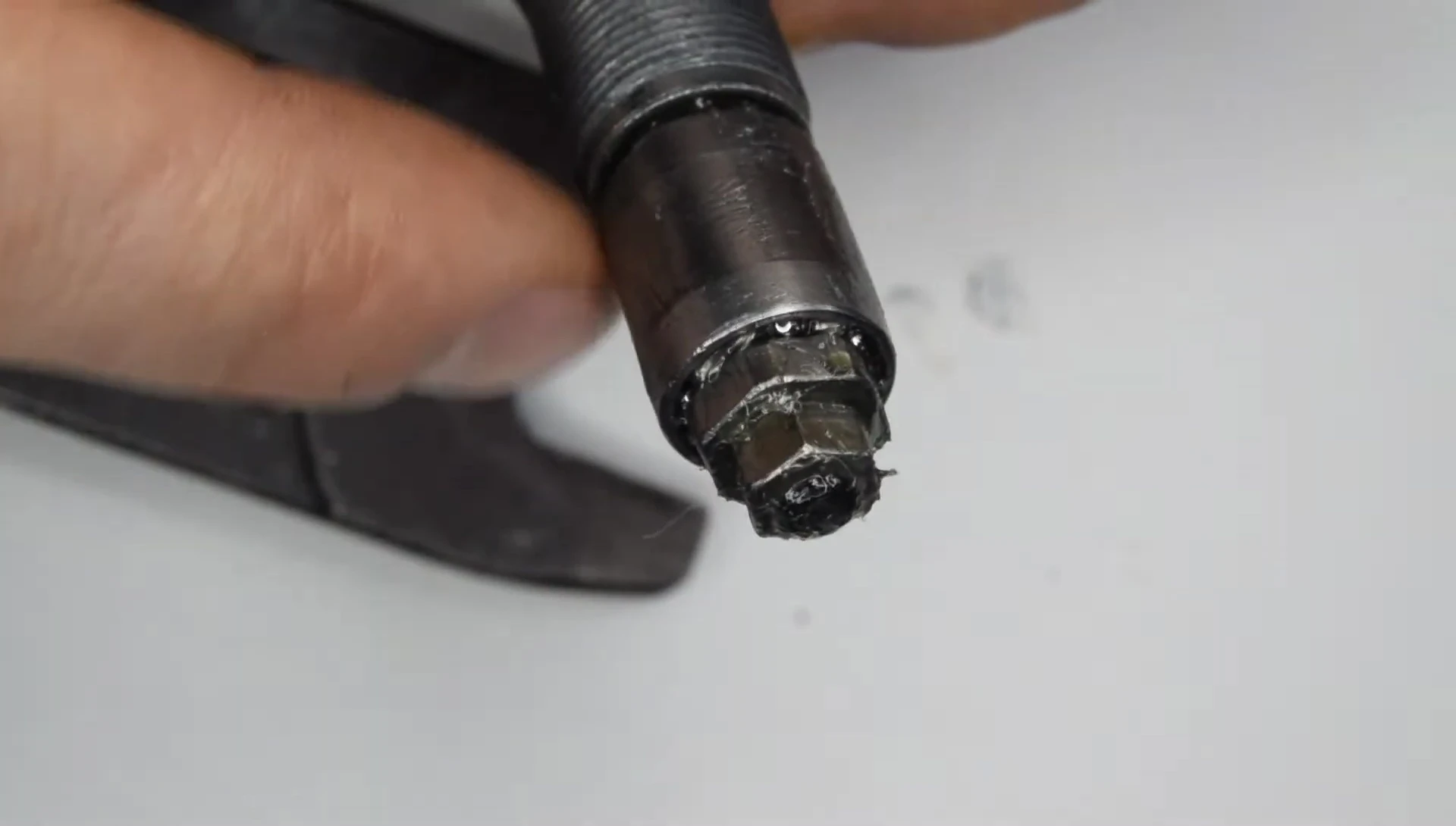 Securing the pedal axle in a vise for cone nut removal.
