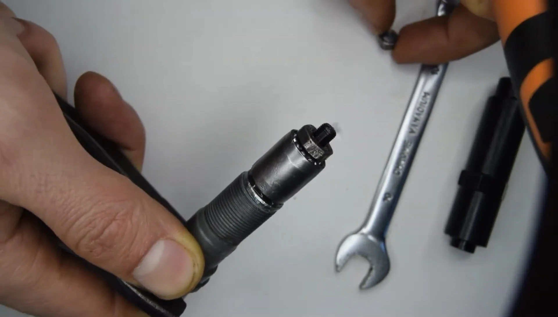 Removing the cone nut and carefully holding the bearings in place.
